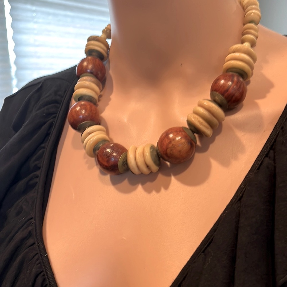 Chunky necklace of wood beads with bone texture discs.